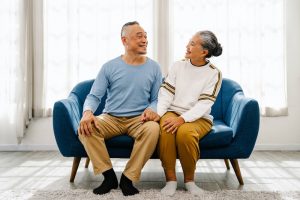 Couple sitting on couch smiling at each other