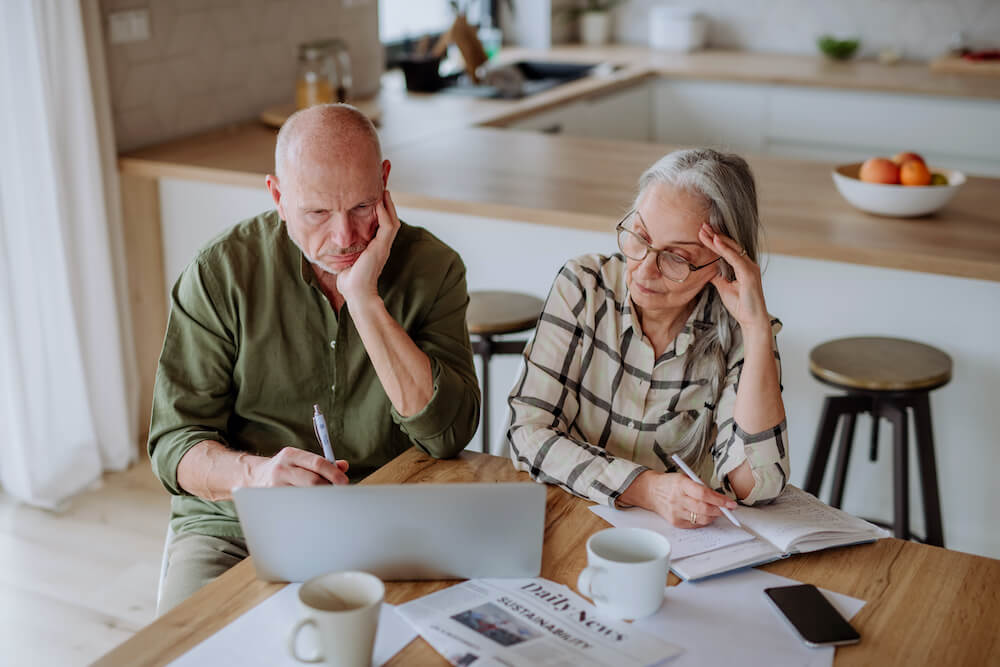 stressed senior couple calculate expenses