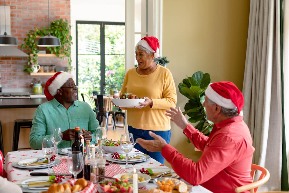 diverse group of happy senior friends in holiday hats